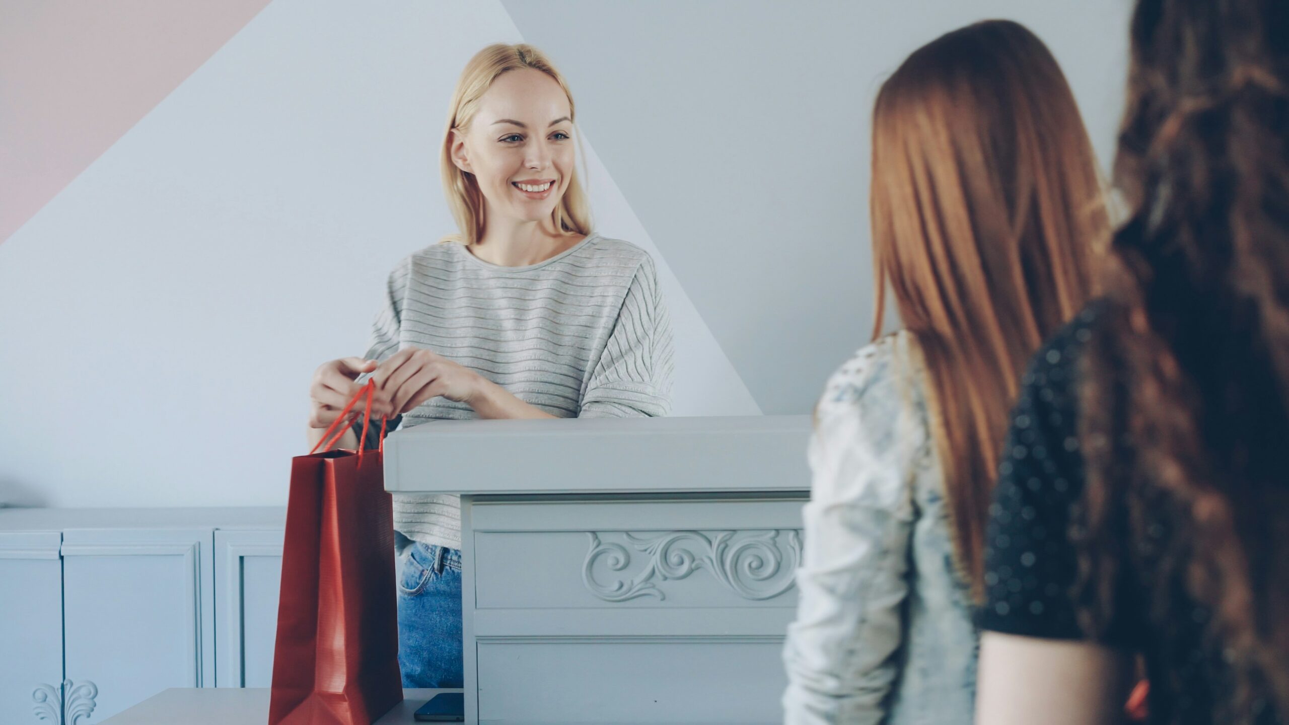 A salesperson handing a product to two clients